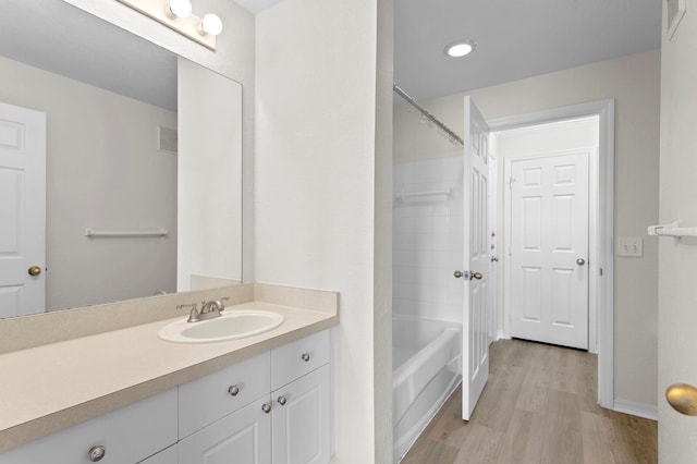 bathroom with vanity, hardwood / wood-style flooring, and shower / bathtub combination