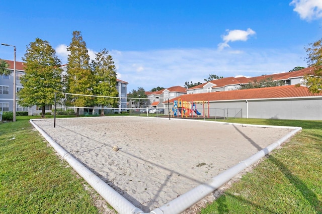 view of community with volleyball court and a lawn