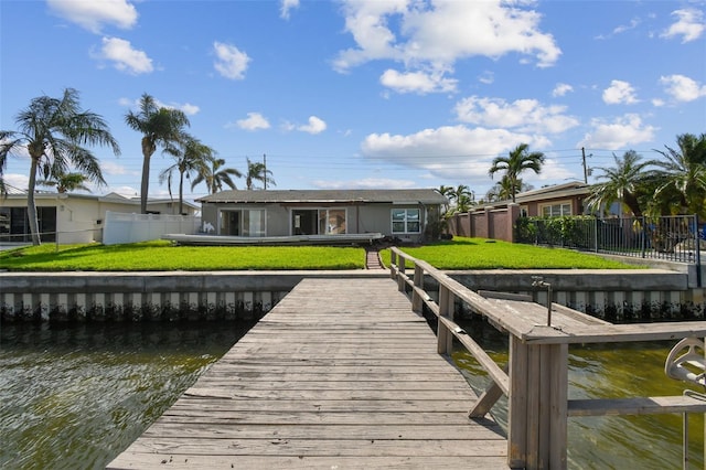 view of dock featuring a water view and a yard