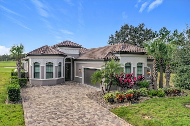 mediterranean / spanish house with a garage and a front yard