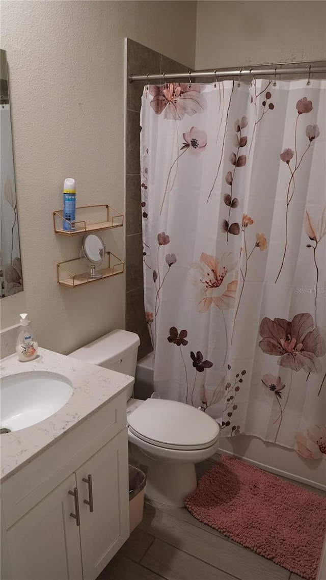 full bathroom featuring wood-type flooring, vanity, shower / bath combination with curtain, and toilet