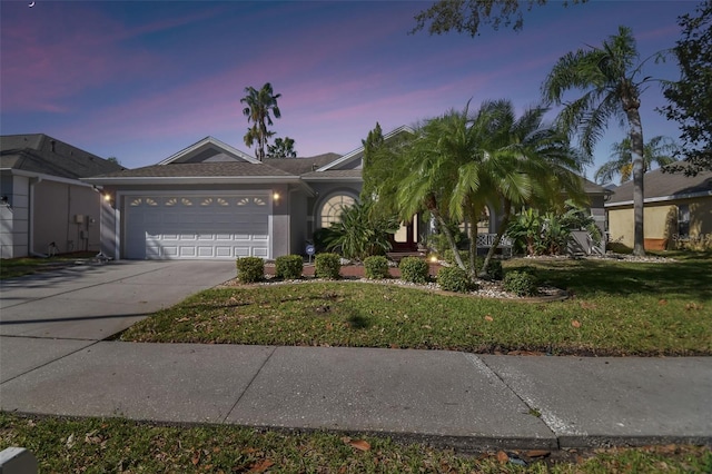 ranch-style house with a garage and a yard