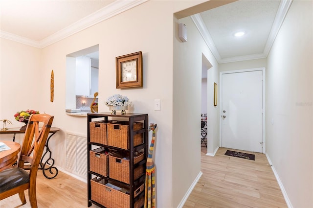 foyer entrance with light wood-type flooring and crown molding