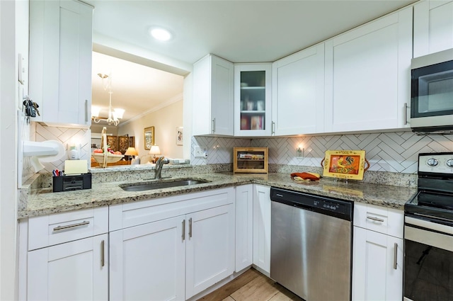 kitchen with backsplash, appliances with stainless steel finishes, and white cabinets