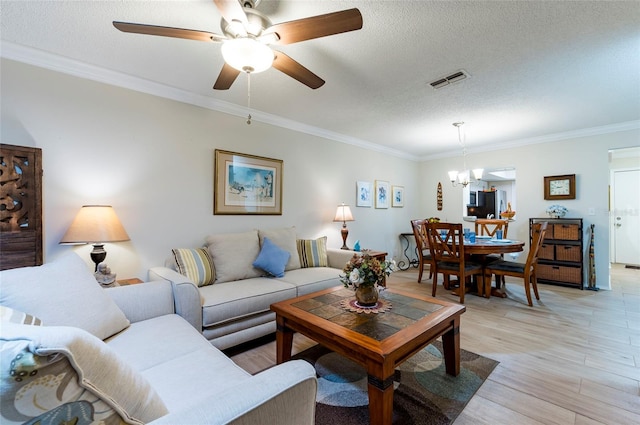 living room with light hardwood / wood-style floors, ceiling fan with notable chandelier, a textured ceiling, and ornamental molding