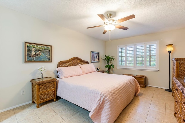 bedroom with a textured ceiling, ceiling fan, and light tile patterned floors