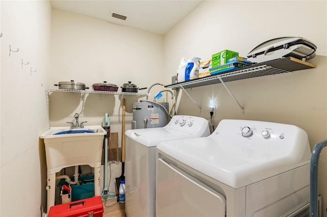 laundry area featuring electric water heater, hardwood / wood-style floors, and washer and dryer