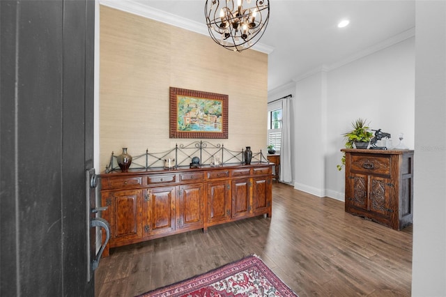 bar with dark wood-type flooring, ornamental molding, and a notable chandelier