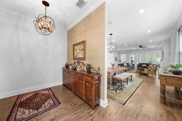 dining room featuring ceiling fan with notable chandelier, hardwood / wood-style flooring, and crown molding