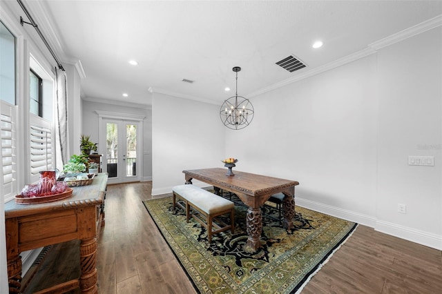 dining space featuring french doors, dark hardwood / wood-style flooring, a chandelier, and crown molding