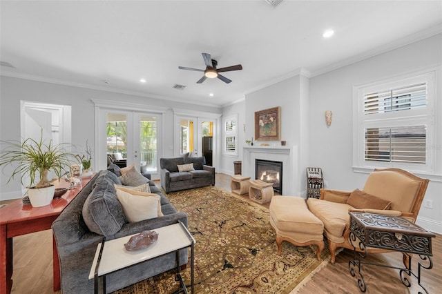 living room featuring ornamental molding, ceiling fan, french doors, and light hardwood / wood-style floors