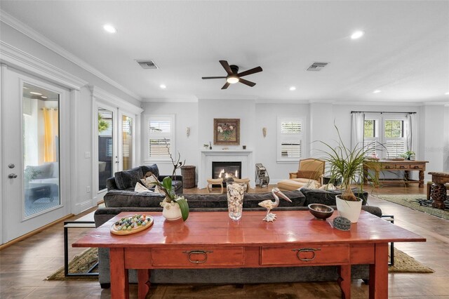 living room with ornamental molding, hardwood / wood-style flooring, and ceiling fan