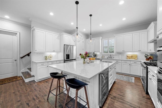 kitchen featuring an island with sink, white cabinets, beverage cooler, and appliances with stainless steel finishes