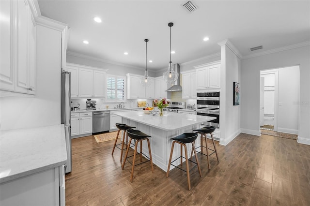 kitchen featuring dark wood-type flooring, white cabinetry, appliances with stainless steel finishes, and a center island