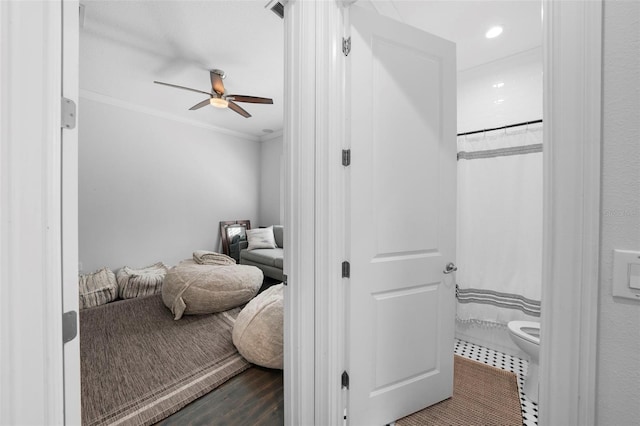 bedroom with dark wood-type flooring, ceiling fan, and ornamental molding