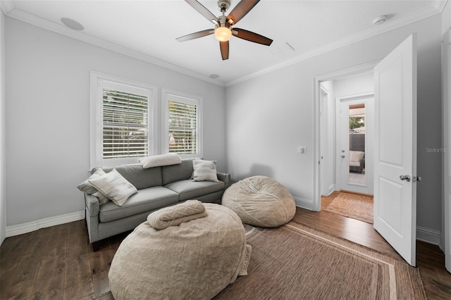 living room with dark wood-type flooring, ceiling fan, and crown molding