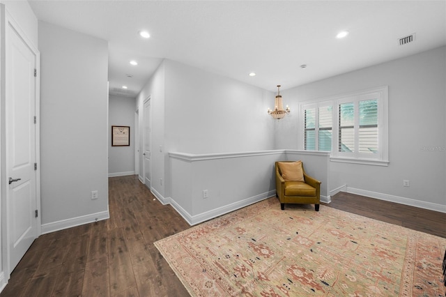 sitting room with dark hardwood / wood-style flooring and a chandelier