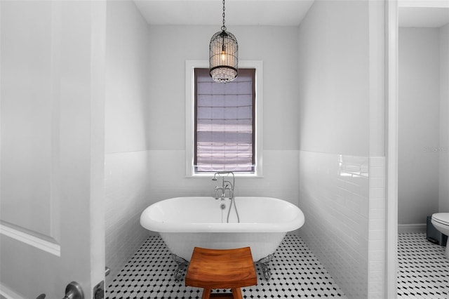 bathroom featuring a bathing tub, tile walls, a notable chandelier, and tile patterned floors