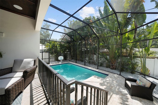 view of swimming pool featuring outdoor lounge area, glass enclosure, and a patio area