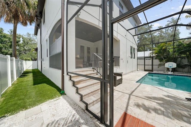 view of pool with glass enclosure and a patio