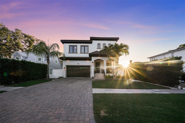 mediterranean / spanish house featuring a lawn and a garage