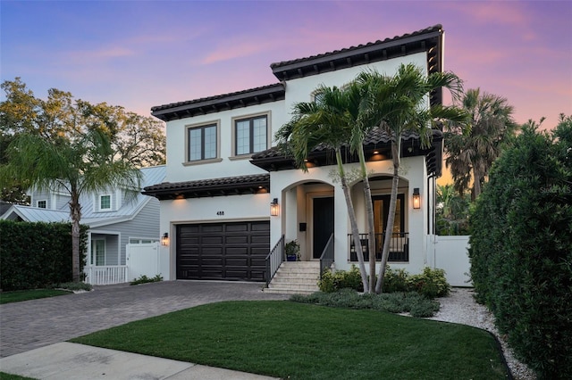 mediterranean / spanish-style house featuring a garage and a yard