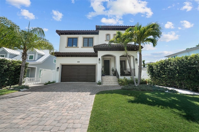 mediterranean / spanish-style house featuring a garage, a front yard, and a porch