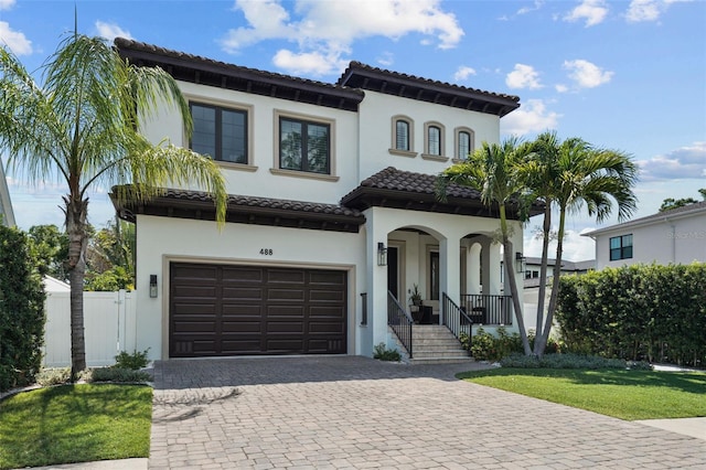 mediterranean / spanish house featuring a garage and a front yard