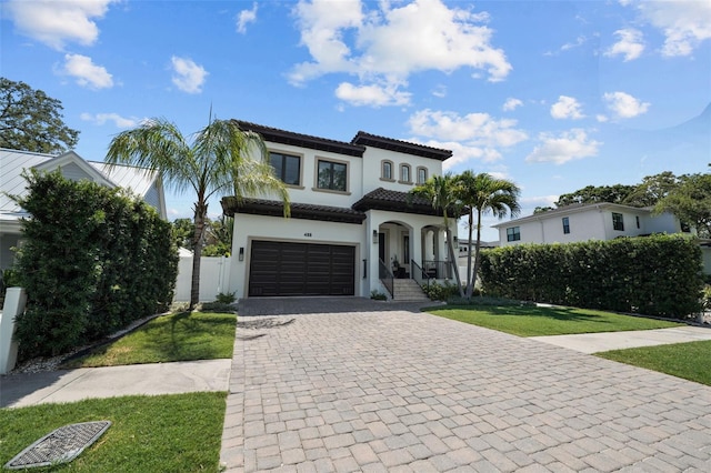 mediterranean / spanish home featuring a garage and a front yard