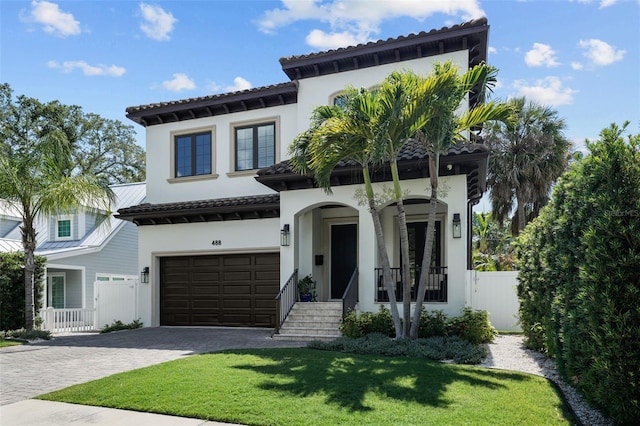 mediterranean / spanish-style house featuring a garage and a front yard