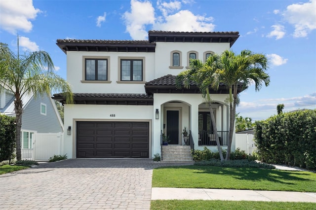 mediterranean / spanish house featuring a front lawn and a garage