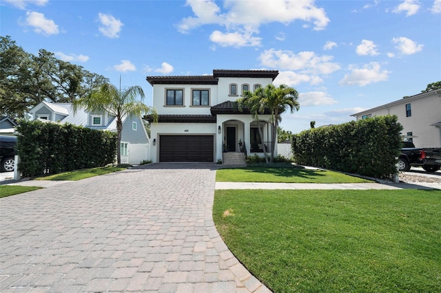 mediterranean / spanish house featuring a garage and a front yard