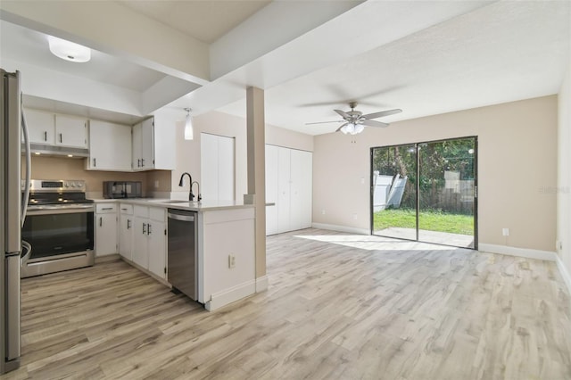 kitchen with appliances with stainless steel finishes, light wood-type flooring, ceiling fan, sink, and white cabinets