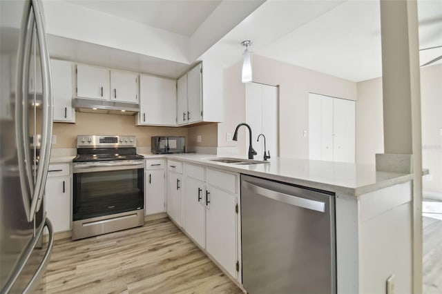 kitchen with white cabinetry, sink, kitchen peninsula, appliances with stainless steel finishes, and light wood-type flooring