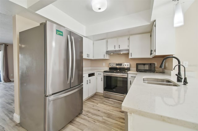 kitchen with sink, white cabinets, stainless steel appliances, and light hardwood / wood-style flooring