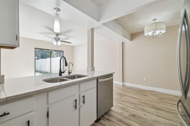 kitchen featuring white cabinets, appliances with stainless steel finishes, hanging light fixtures, and sink