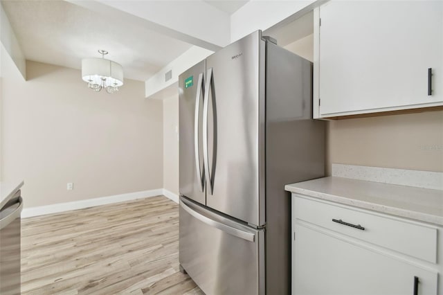 kitchen featuring white cabinetry, pendant lighting, and stainless steel appliances