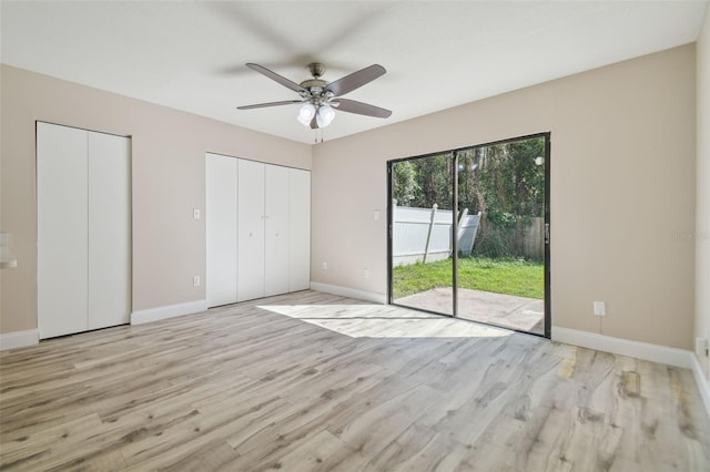 unfurnished bedroom featuring access to exterior, ceiling fan, light hardwood / wood-style flooring, and multiple closets