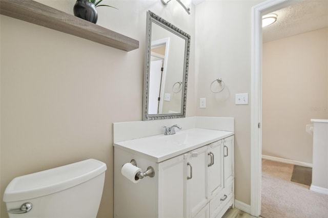 bathroom with vanity, a textured ceiling, and toilet