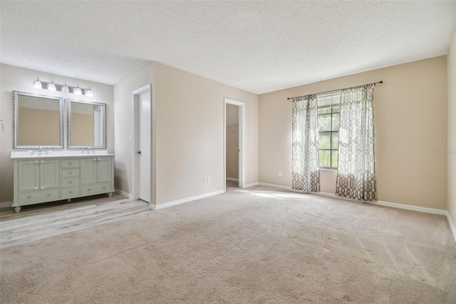 unfurnished bedroom featuring a textured ceiling, a walk in closet, and a closet