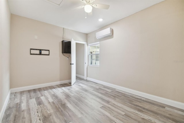 empty room with ceiling fan, light hardwood / wood-style floors, and a wall unit AC