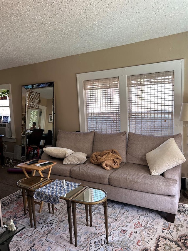 living room featuring a wealth of natural light, a textured ceiling, and cooling unit