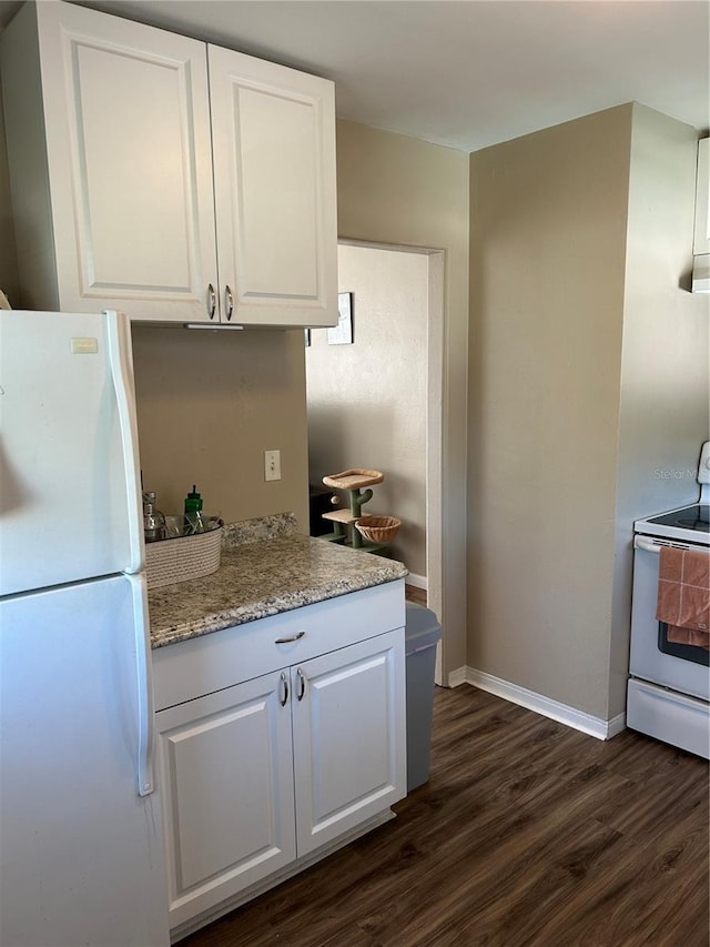 kitchen with white cabinets, dark wood-type flooring, white appliances, and light stone countertops