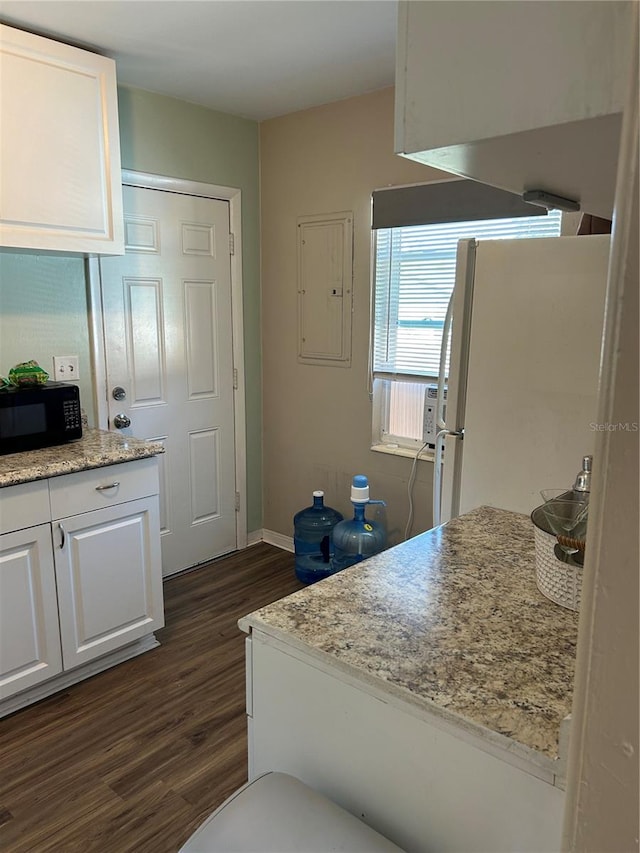 kitchen with white cabinetry, electric panel, light stone counters, dark wood-type flooring, and white refrigerator