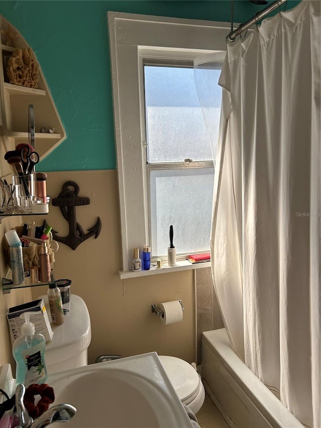 bathroom featuring shower / bath combo with shower curtain and toilet