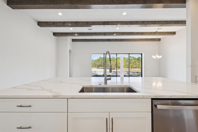 kitchen with light stone counters, white cabinetry, dishwasher, and a sink