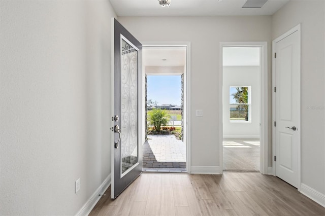 entrance foyer with baseboards, visible vents, and light wood-style floors