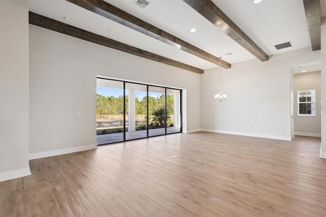 spare room with a chandelier, baseboards, visible vents, and light wood finished floors