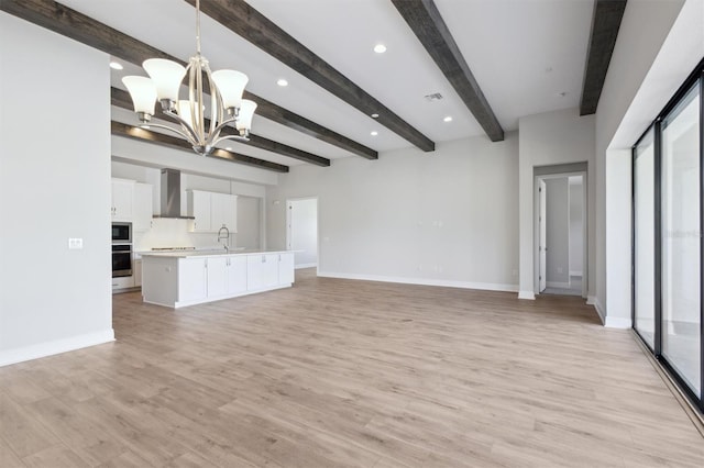 unfurnished living room with light wood-style floors, baseboards, and a chandelier