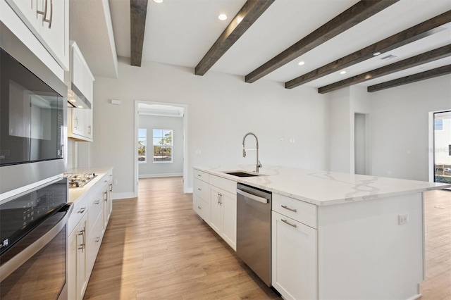 kitchen featuring stainless steel appliances, light wood-style flooring, white cabinets, a sink, and an island with sink